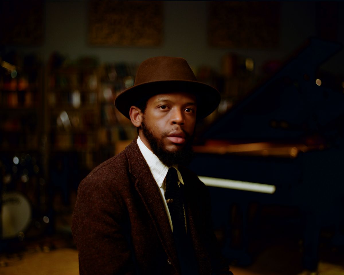 Sean Mason in a hat at the piano in the studio